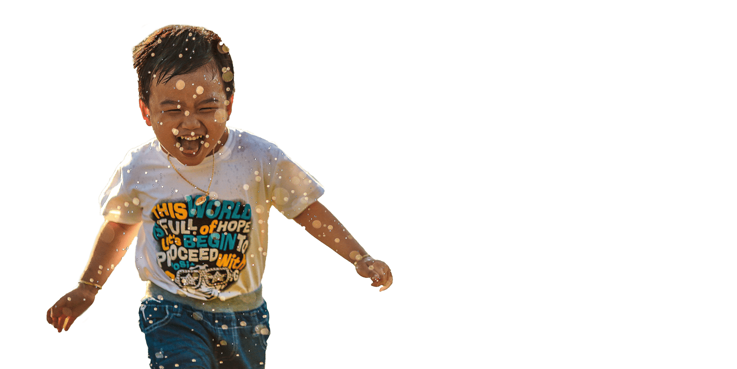 A small boy running and laughing.