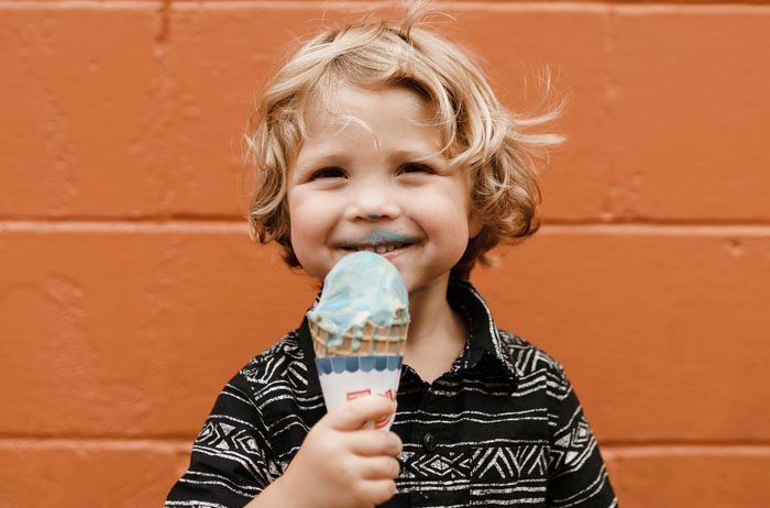 A boy eating an ice cream cone.