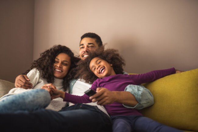 Relaxed African American Family Watching TV Together