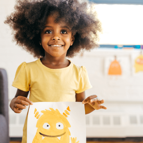 African American girl shows a picture she drew of a monster
